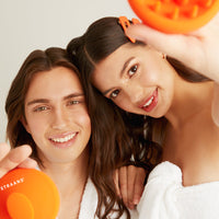 Brand Models holding the Straand Scalp Scrubber with happy facial expressions